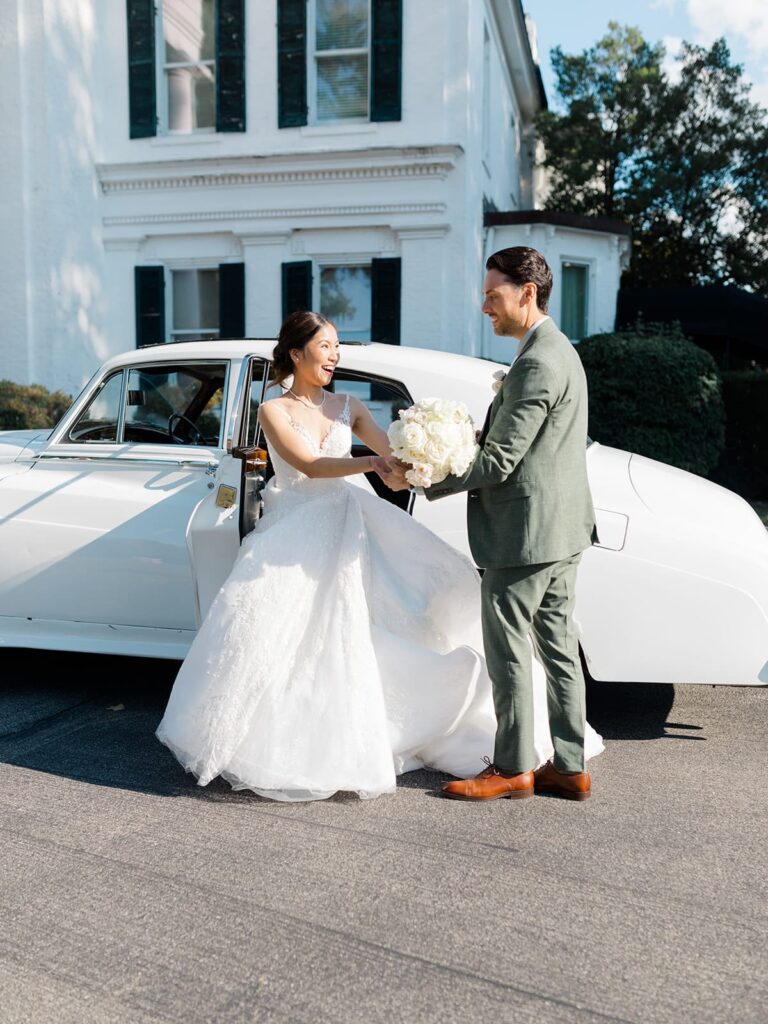 Bride and Groom posing for a photo in front of their wedding venue captured from a second photographers perspective. 