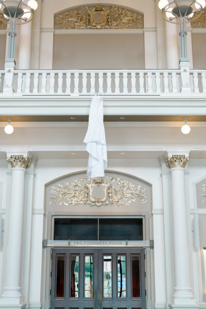 Wedding detail photo of the brides dress hanging at her venue at Cincinnati Music Hall