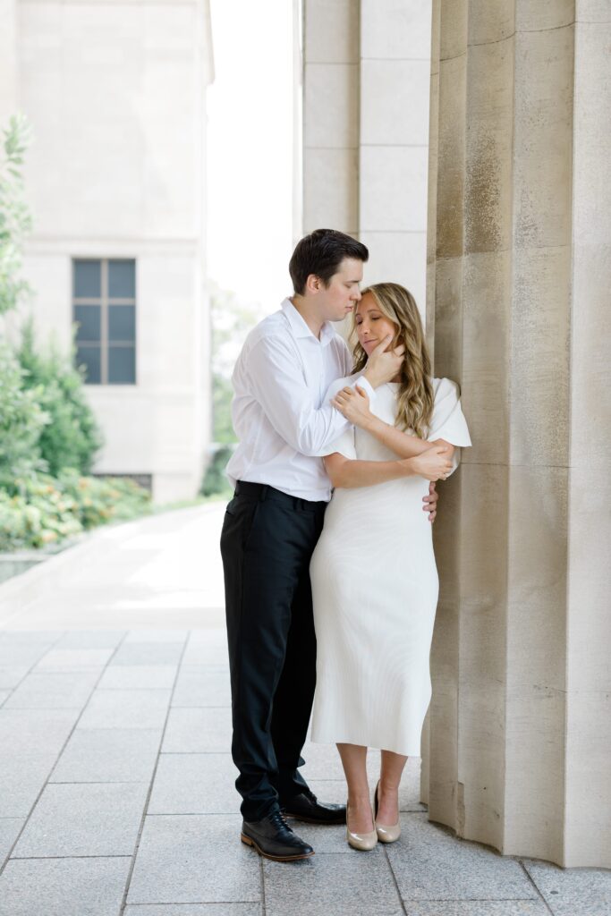 Engaged couple posing for a photo in front of the Cincinnati Art Museum.