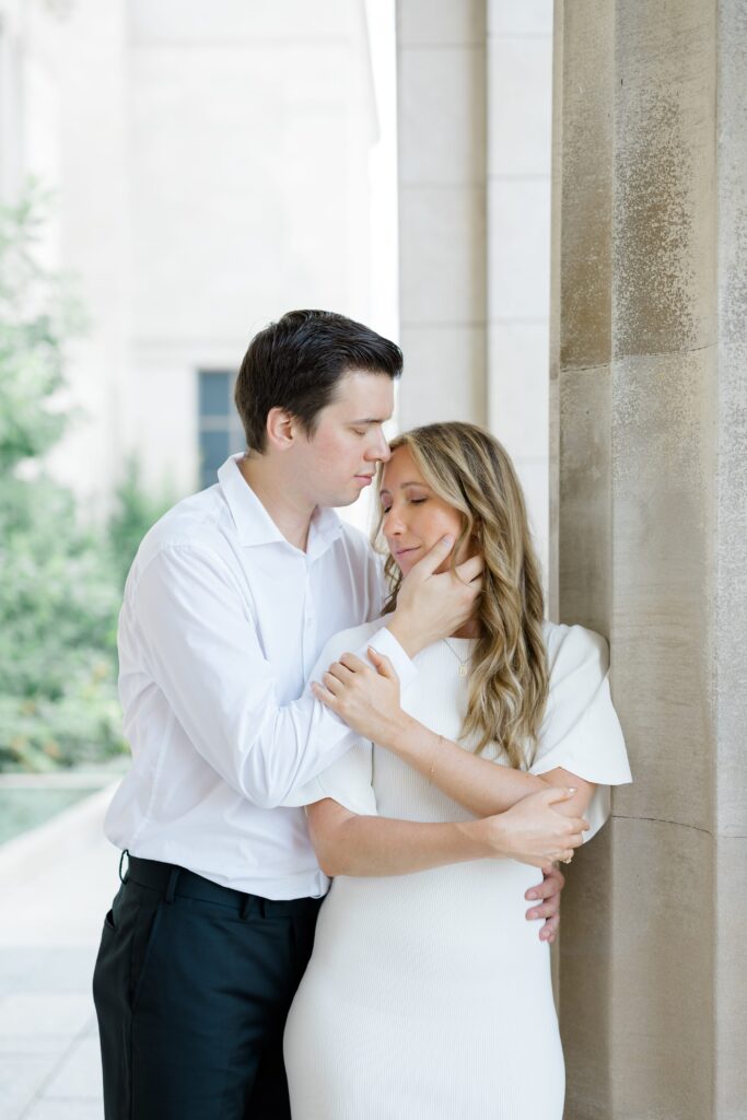 Engaged couple posing for a photo in front of the Cincinnati Art Museum.