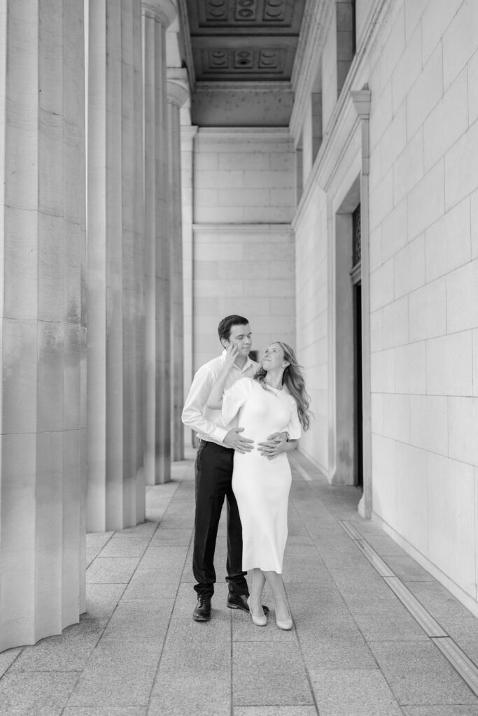 Engaged couple posing for a photo in front of the Cincinnati Art Museum.