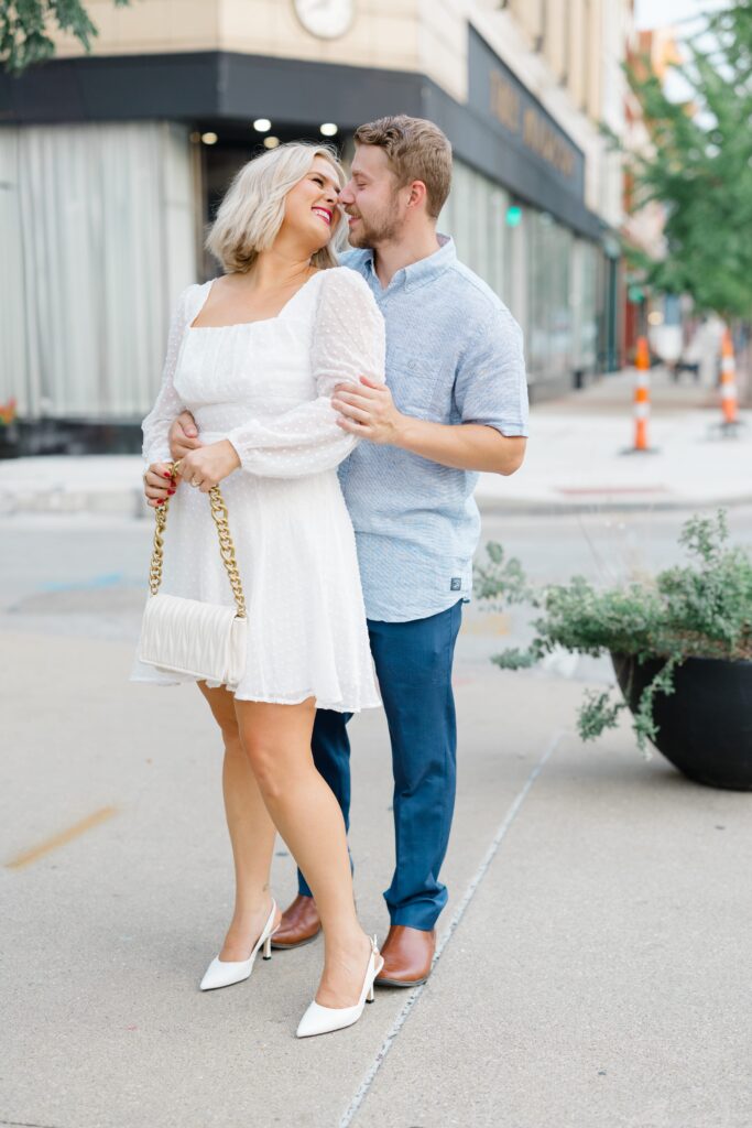 Engaged couple posing for a photo near Hotel Covington.