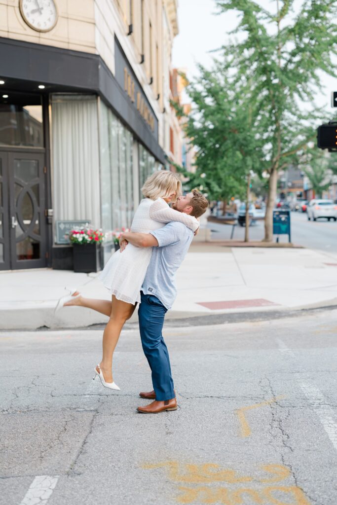 Engaged couple posing for a photo in front of Hotel Covington.