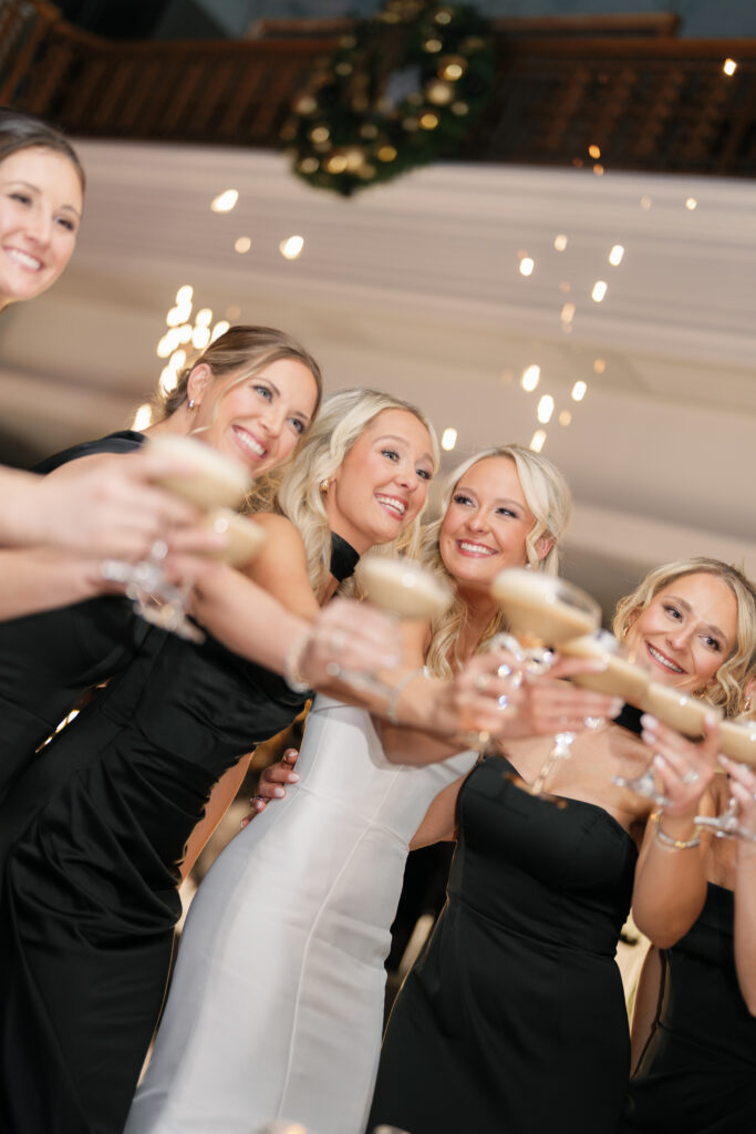 bride and bridesmaids cheers with matching drinks