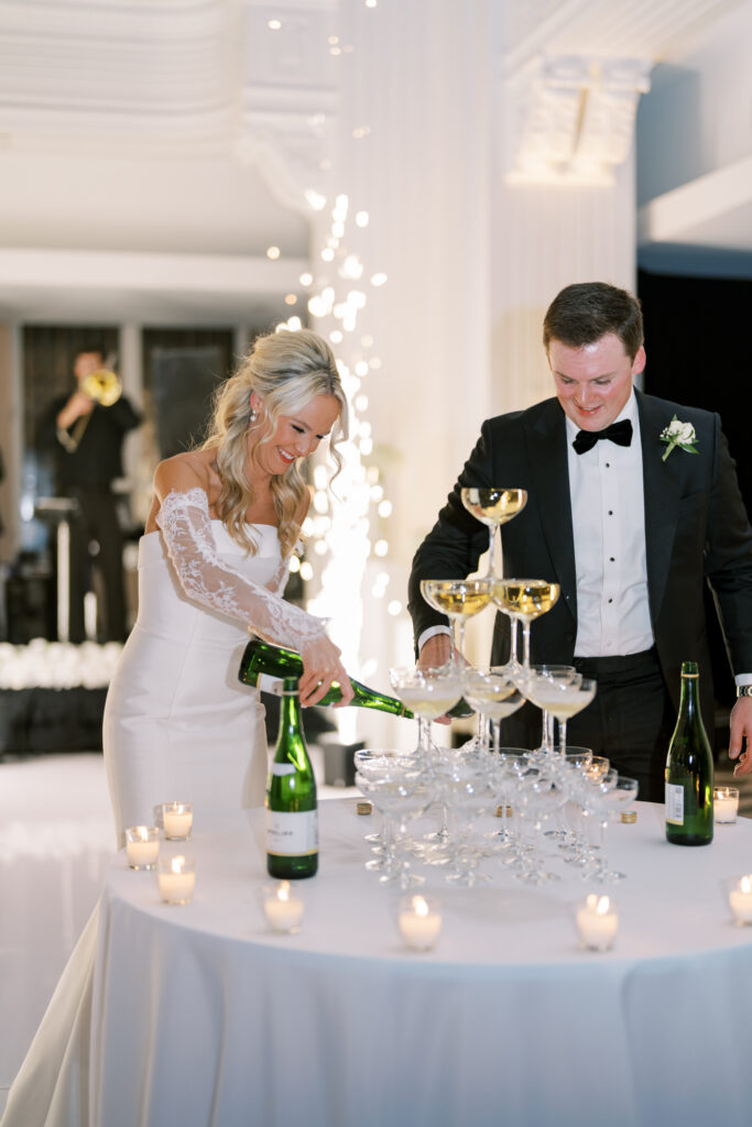 bride and groom fill glasses at champagne tower inside Cincinnati Renaissance Hotel wedding